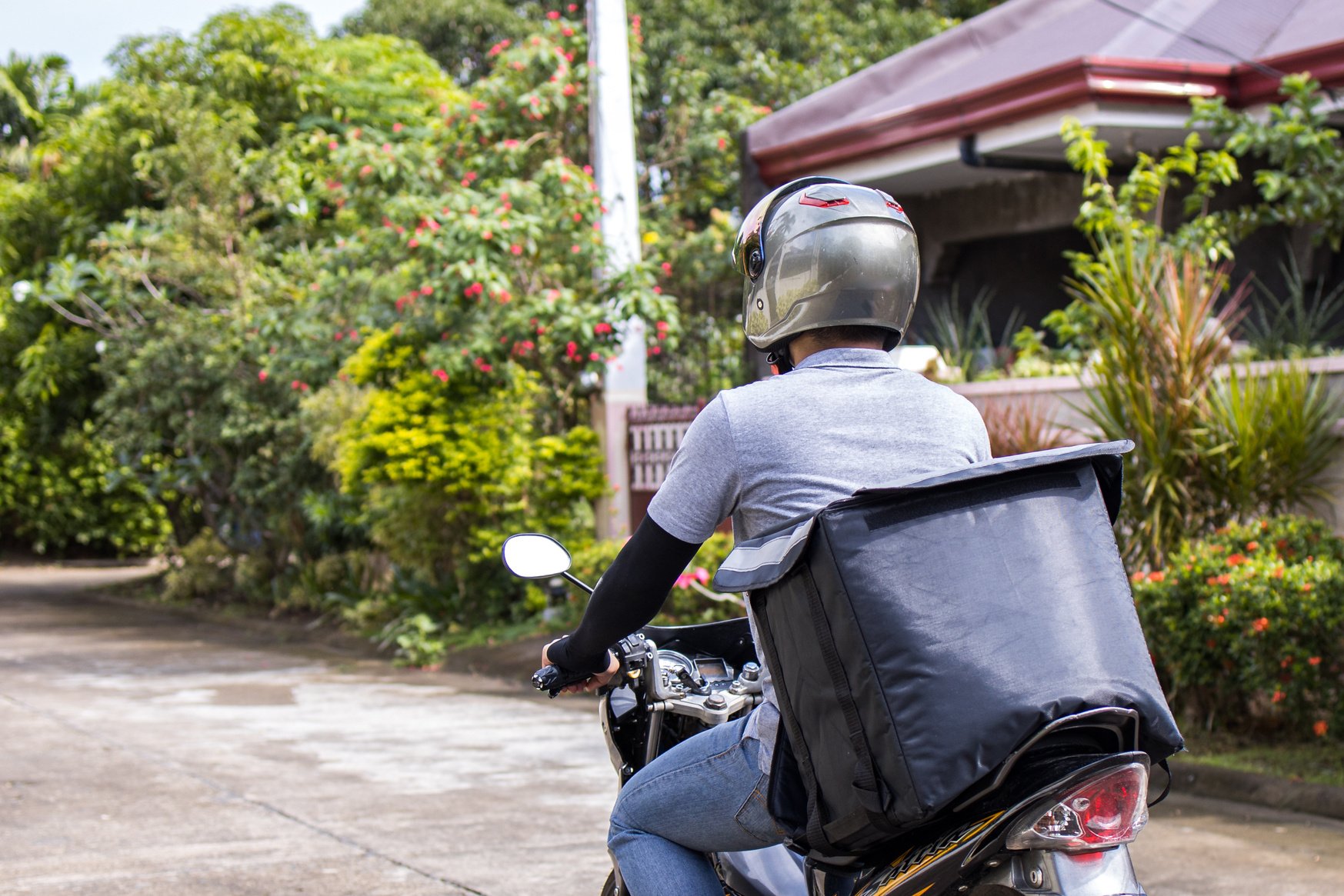 Delivery Man Riding on his Motorcycle Delivering Package